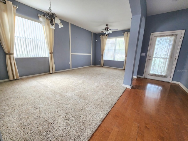 interior space with ceiling fan with notable chandelier