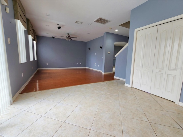 unfurnished living room with light tile patterned floors and ceiling fan