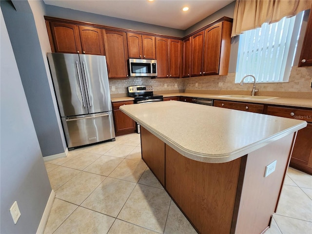 kitchen with sink, tasteful backsplash, light tile patterned floors, a kitchen island, and stainless steel appliances