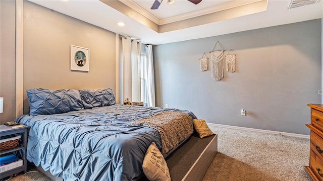 bedroom with crown molding, a tray ceiling, carpet floors, and ceiling fan