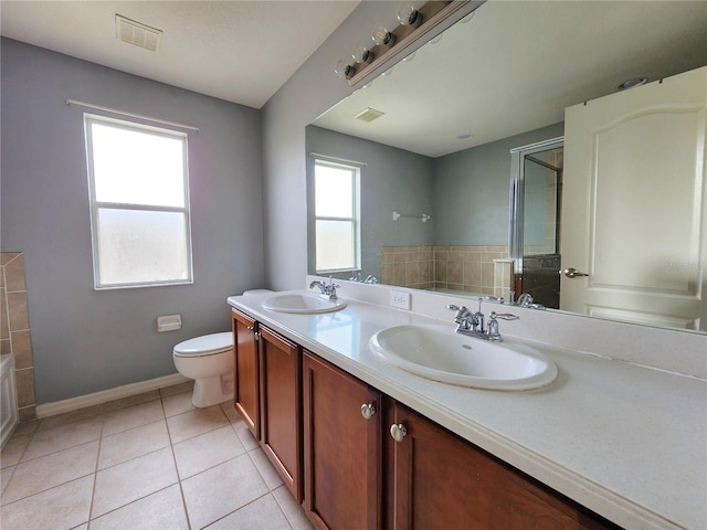 bathroom with tile patterned flooring, vanity, a shower with door, and toilet