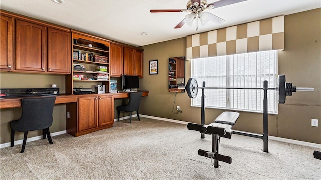 office area with light carpet, built in desk, and ceiling fan