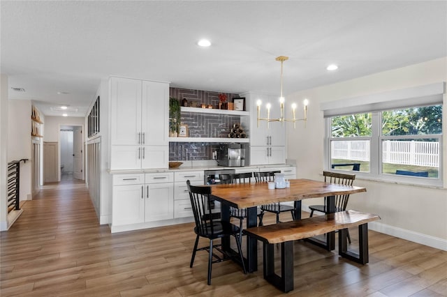 dining room with hardwood / wood-style floors and a notable chandelier