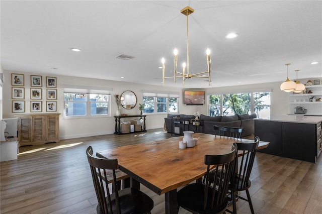 dining area featuring dark hardwood / wood-style flooring, an inviting chandelier, and plenty of natural light