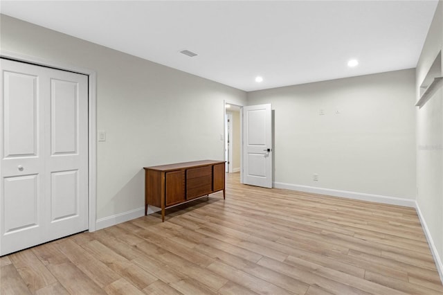 bedroom with a closet and light hardwood / wood-style flooring