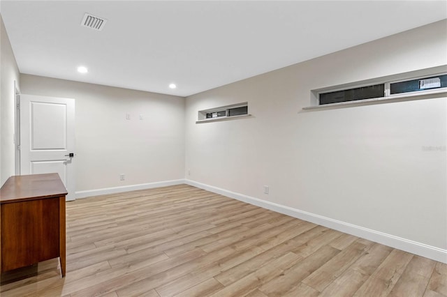 basement with light hardwood / wood-style flooring