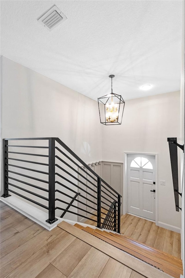 entrance foyer featuring a notable chandelier and wood-type flooring