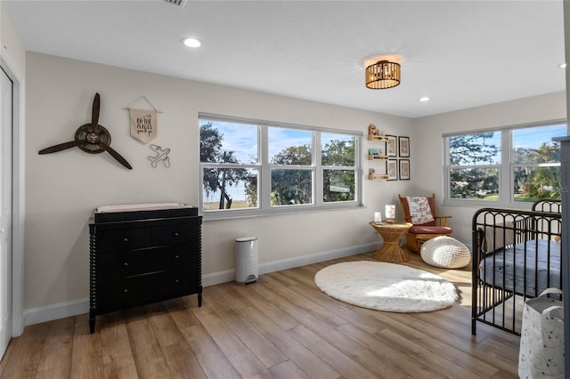 sitting room with ceiling fan and light wood-type flooring