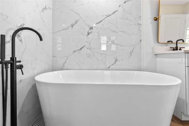 bathroom featuring a washtub and vanity