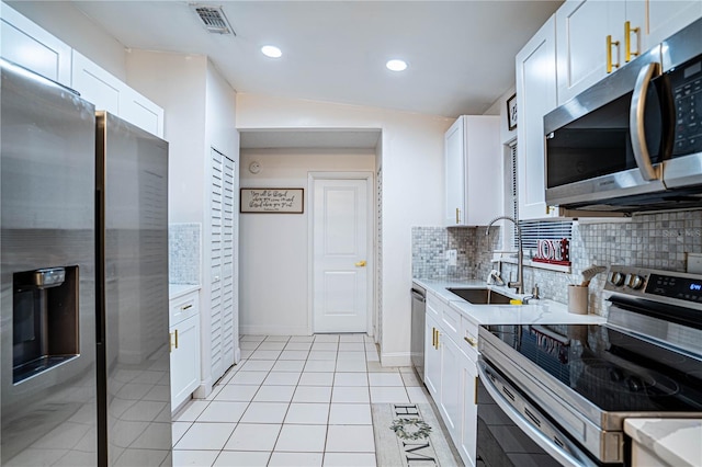 kitchen featuring sink, white cabinets, vaulted ceiling, and appliances with stainless steel finishes