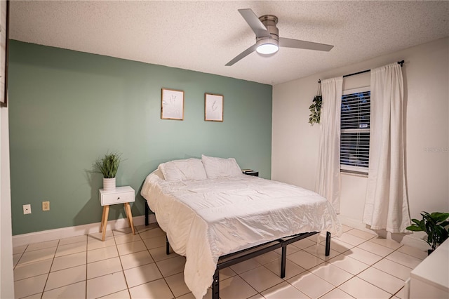 tiled bedroom with ceiling fan and a textured ceiling