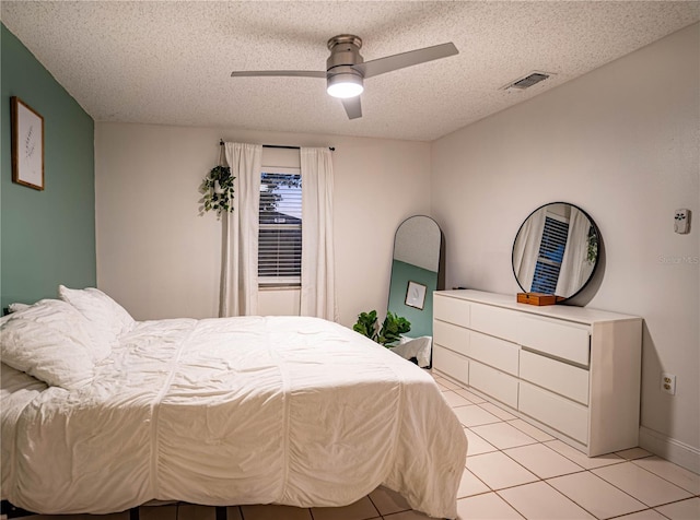 tiled bedroom featuring ceiling fan and a textured ceiling