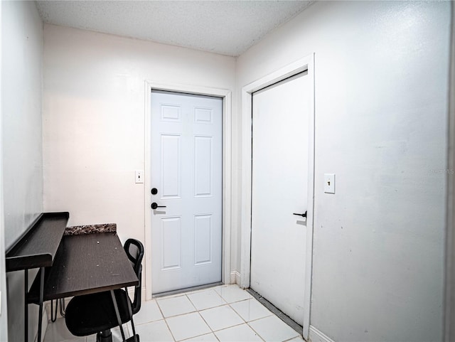 entryway featuring a textured ceiling and light tile patterned flooring