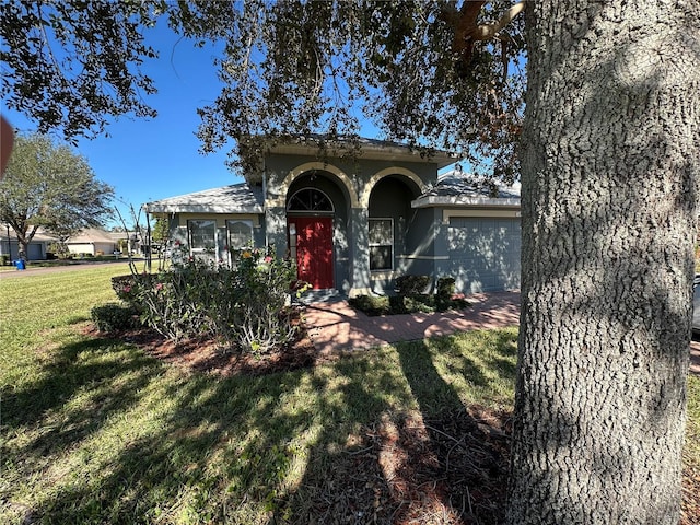 view of front of property with a garage and a front lawn