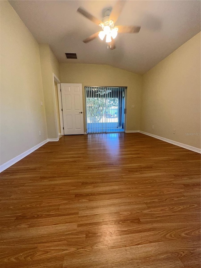 spare room with hardwood / wood-style flooring, vaulted ceiling, and ceiling fan