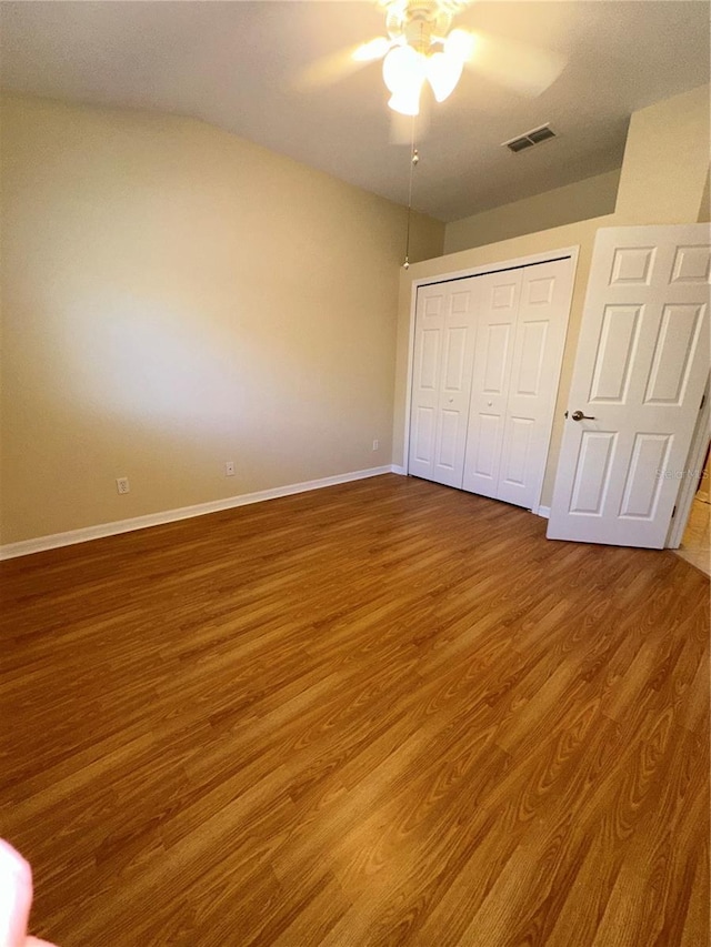 unfurnished bedroom with ceiling fan, a closet, and hardwood / wood-style flooring