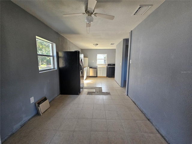 interior space with ceiling fan, a textured ceiling, and a wealth of natural light