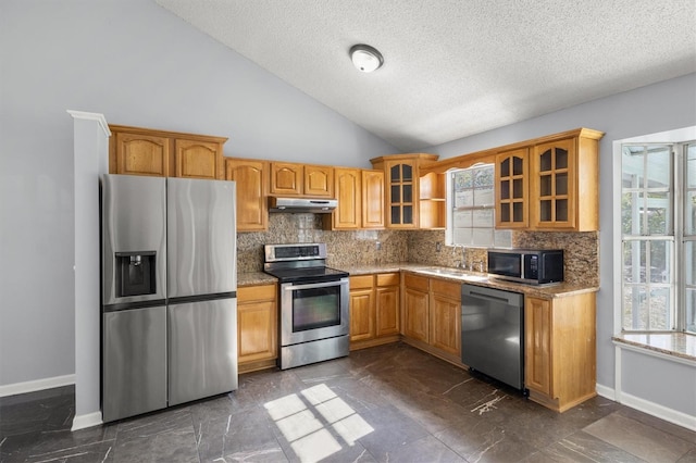 kitchen with backsplash, high vaulted ceiling, sink, a textured ceiling, and stainless steel appliances