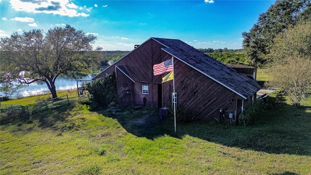 view of property exterior featuring a water view and a yard