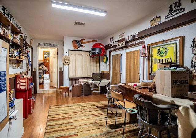 dining area with bar area and light hardwood / wood-style floors