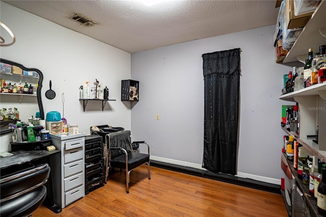 office area with hardwood / wood-style floors and a textured ceiling