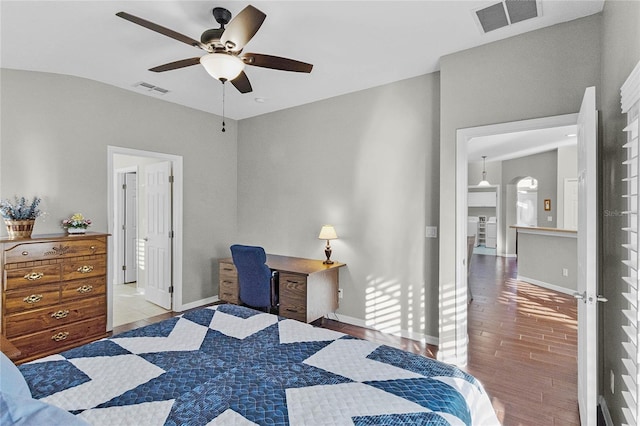 bedroom with baseboards, visible vents, and wood finished floors