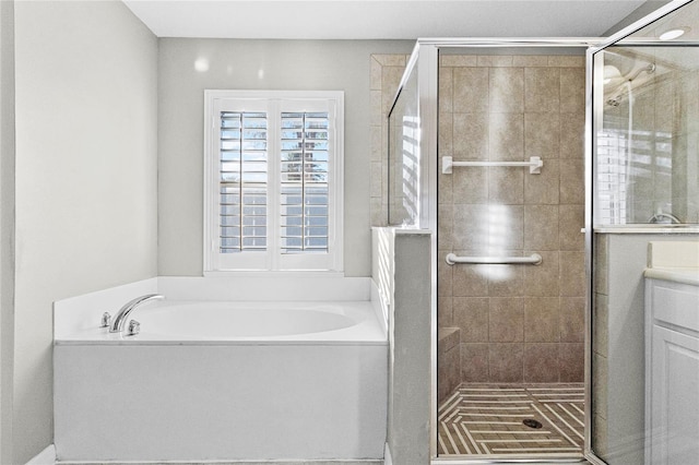 bathroom with a garden tub, vanity, and a stall shower