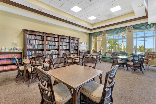 carpeted dining space featuring a tray ceiling and a high ceiling