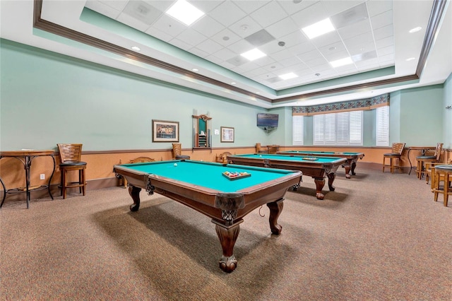 rec room featuring a tray ceiling, a wainscoted wall, pool table, carpet flooring, and a drop ceiling