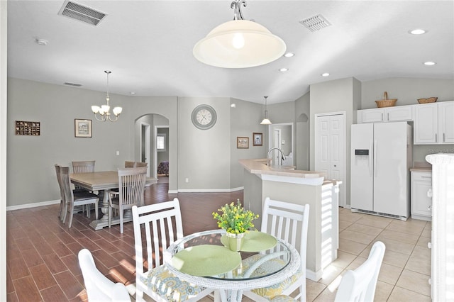 dining area featuring arched walkways, visible vents, lofted ceiling, and recessed lighting