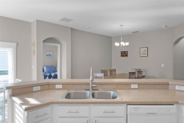 kitchen featuring visible vents, dishwasher, light countertops, white cabinetry, and a sink