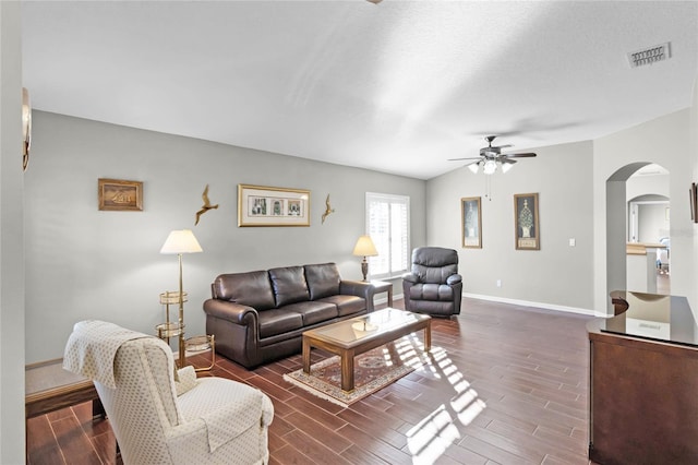 living room featuring wood finish floors, arched walkways, visible vents, a ceiling fan, and baseboards