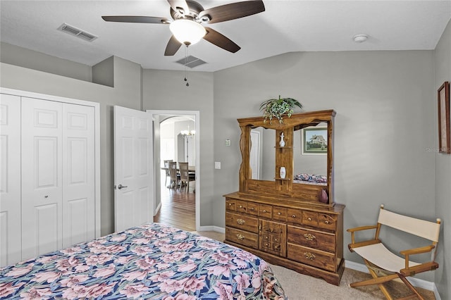 bedroom with a closet, visible vents, vaulted ceiling, and arched walkways