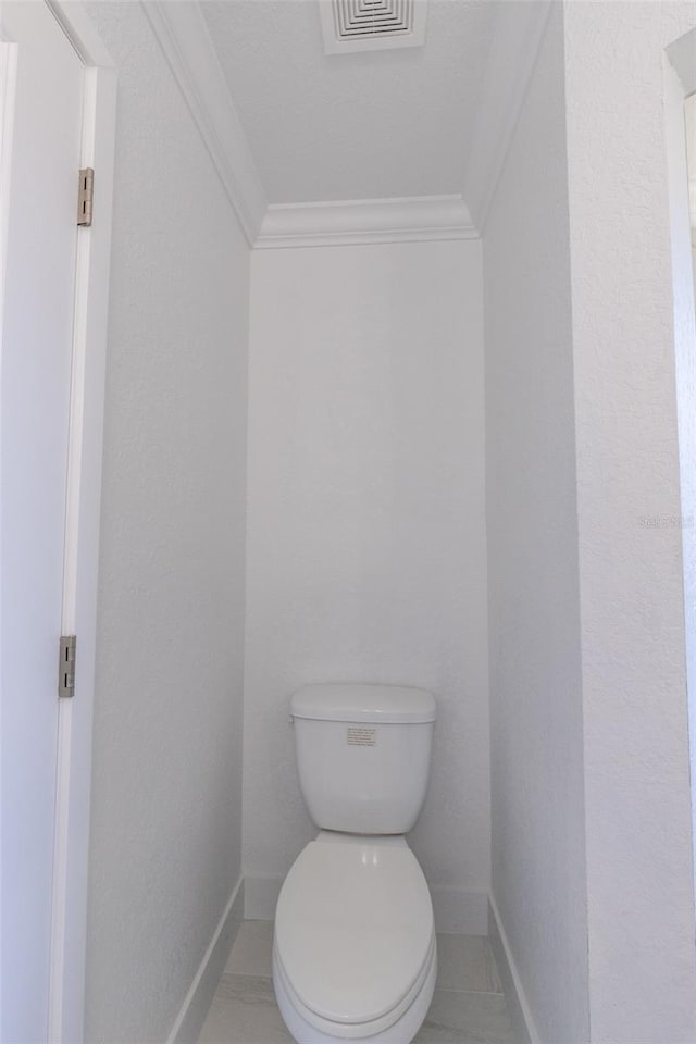 bathroom featuring tile patterned floors, toilet, and ornamental molding