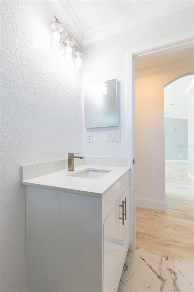 bathroom featuring hardwood / wood-style floors, vanity, and ornamental molding