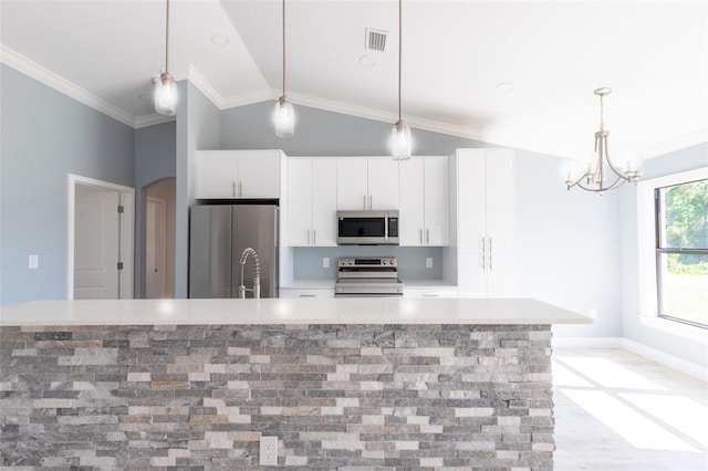 kitchen featuring white cabinets, crown molding, vaulted ceiling, an island with sink, and appliances with stainless steel finishes