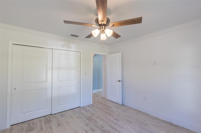 unfurnished bedroom with ceiling fan, light hardwood / wood-style floors, crown molding, and a closet