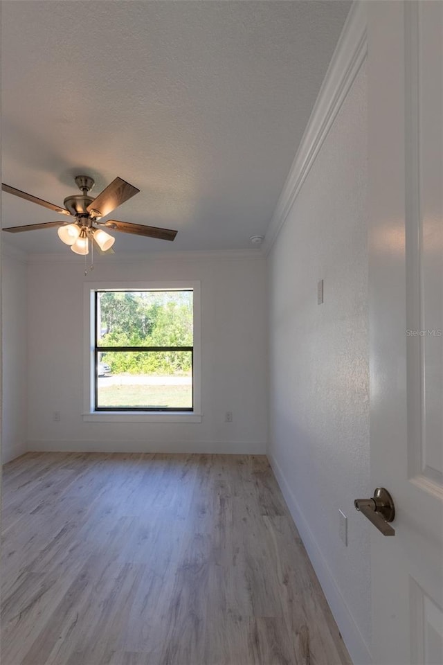 empty room featuring a textured ceiling, light hardwood / wood-style flooring, ceiling fan, and crown molding