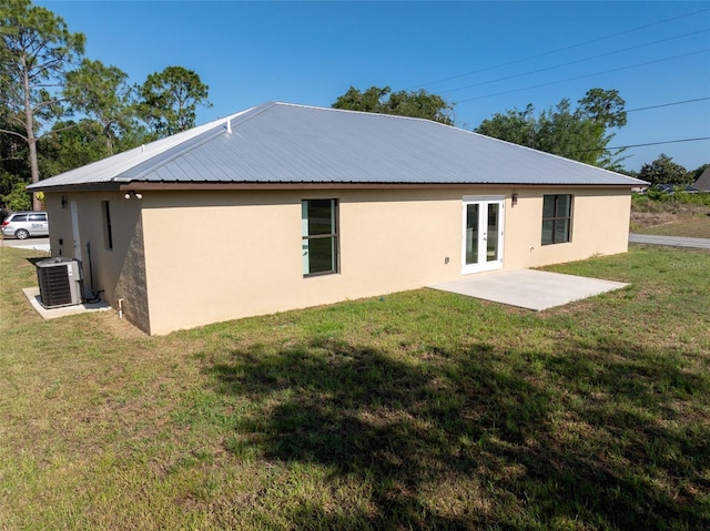 rear view of property with a yard, a patio area, french doors, and cooling unit