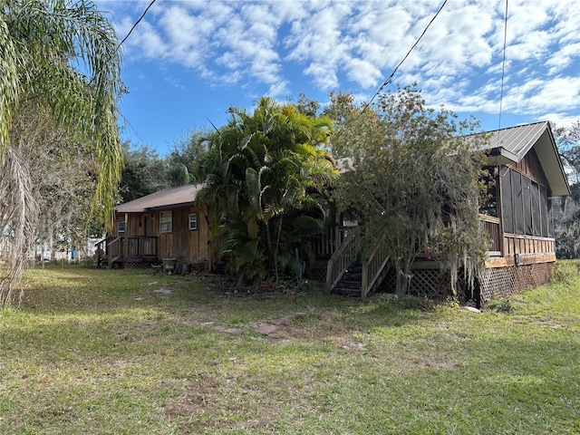 view of side of property featuring a sunroom and a lawn