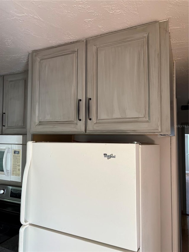 details featuring white appliances and a textured ceiling