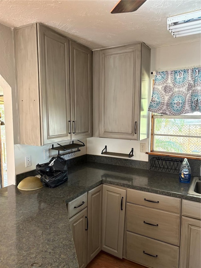 kitchen featuring light brown cabinets, a textured ceiling, and sink