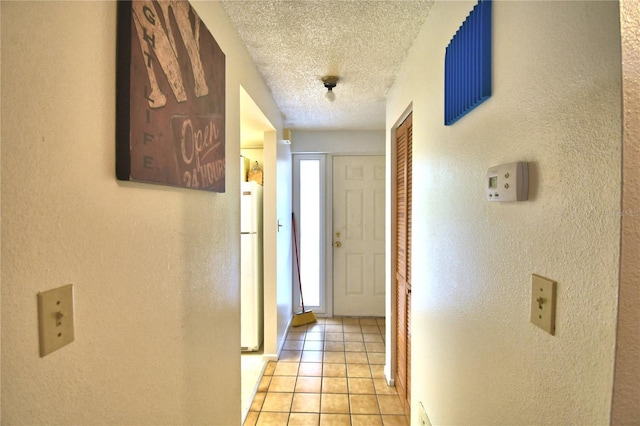 corridor with a textured ceiling, plenty of natural light, and light tile patterned flooring