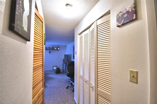 corridor featuring carpet and a textured ceiling