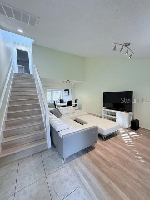 living room featuring a textured ceiling and light hardwood / wood-style flooring