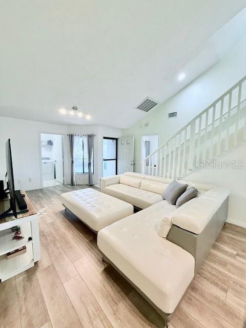 living room with light hardwood / wood-style floors and washer / dryer