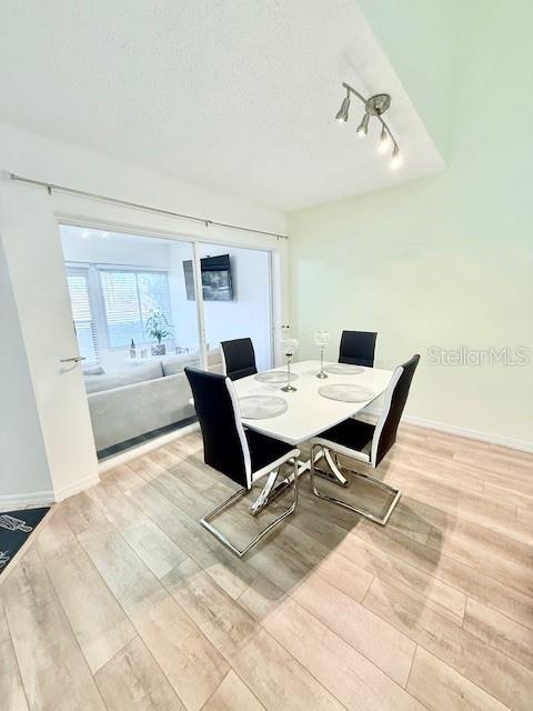 dining room with a textured ceiling and light hardwood / wood-style floors