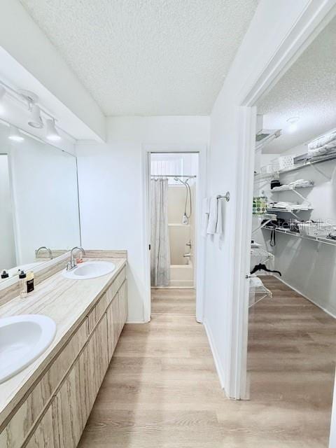 bathroom with vanity, tub / shower combination, a textured ceiling, and hardwood / wood-style flooring