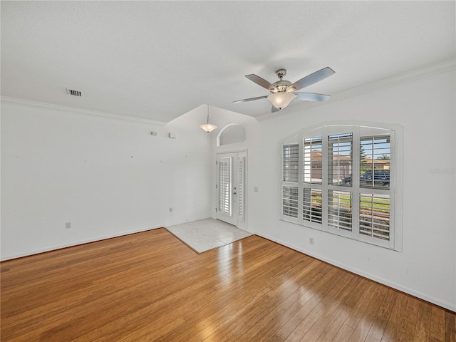 spare room featuring ceiling fan, ornamental molding, and light hardwood / wood-style flooring