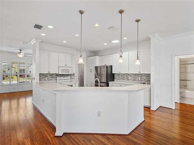 kitchen with white cabinetry, dark hardwood / wood-style flooring, kitchen peninsula, pendant lighting, and white appliances